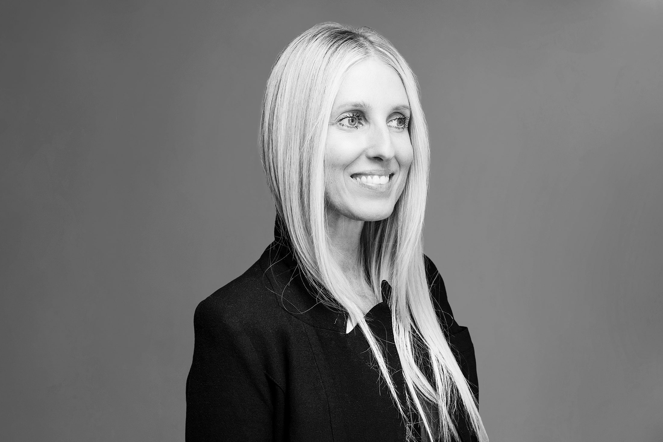 a black and white photo of a woman smiling.