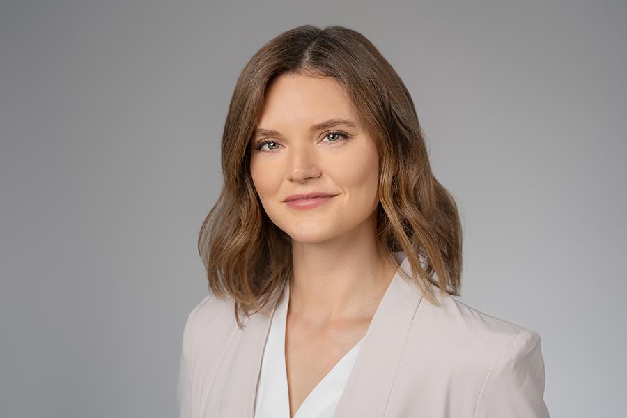 a woman in a white blazer posing for a photo.