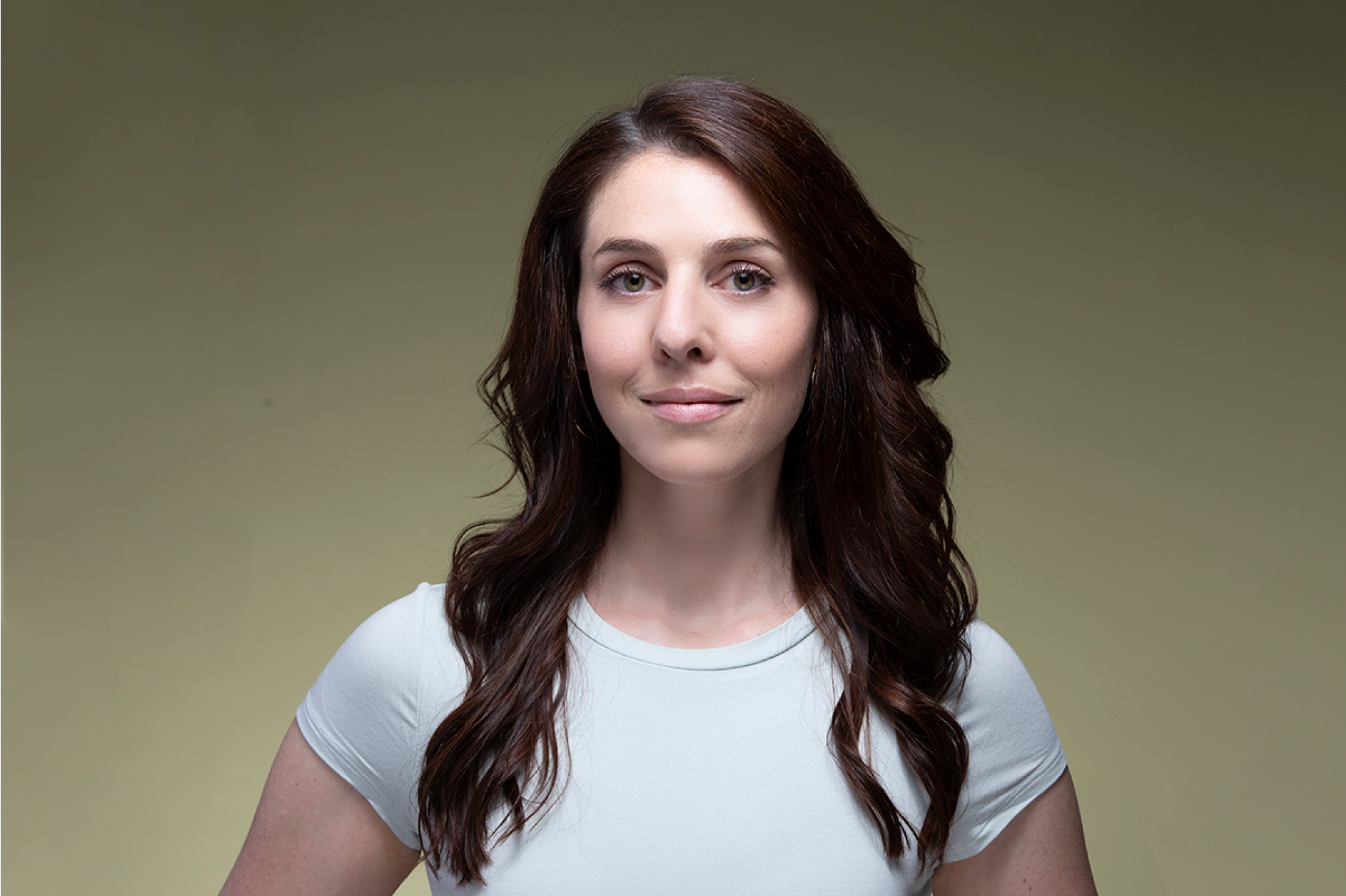 A woman posing for a headshot photo against a white background.