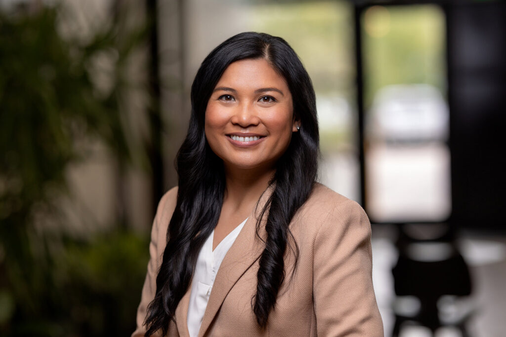 Professional woman smiling in a Denver office environment, perfect for headshots.