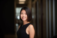 Professional woman smiling in a Denver office environment, perfect for professional headshots.