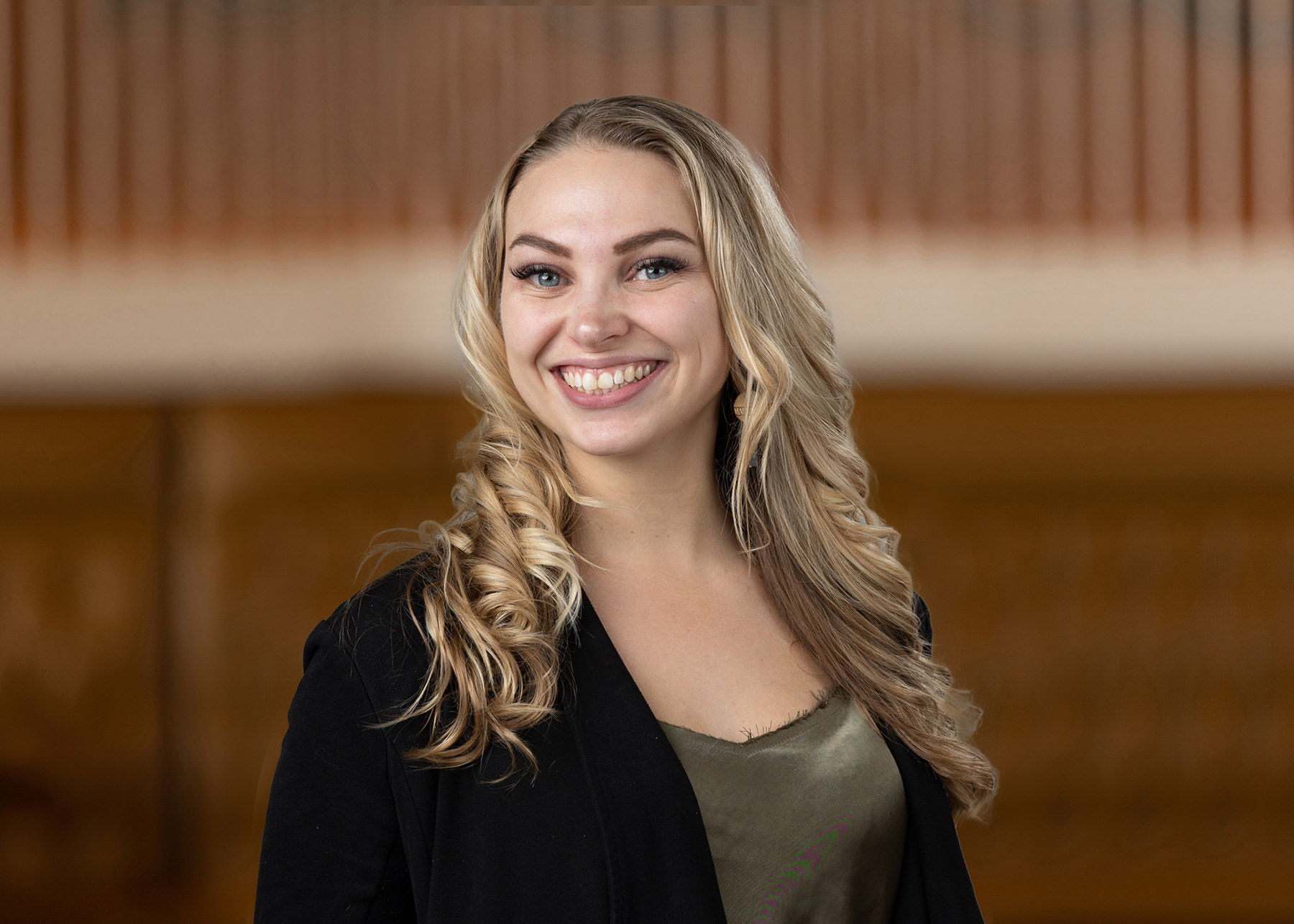 Portrait of a smiling woman with blonde hair in a professional setting, ideal for Denver headshots.