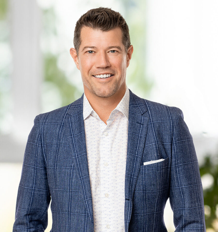 headshot of man in blue coat and white shirt